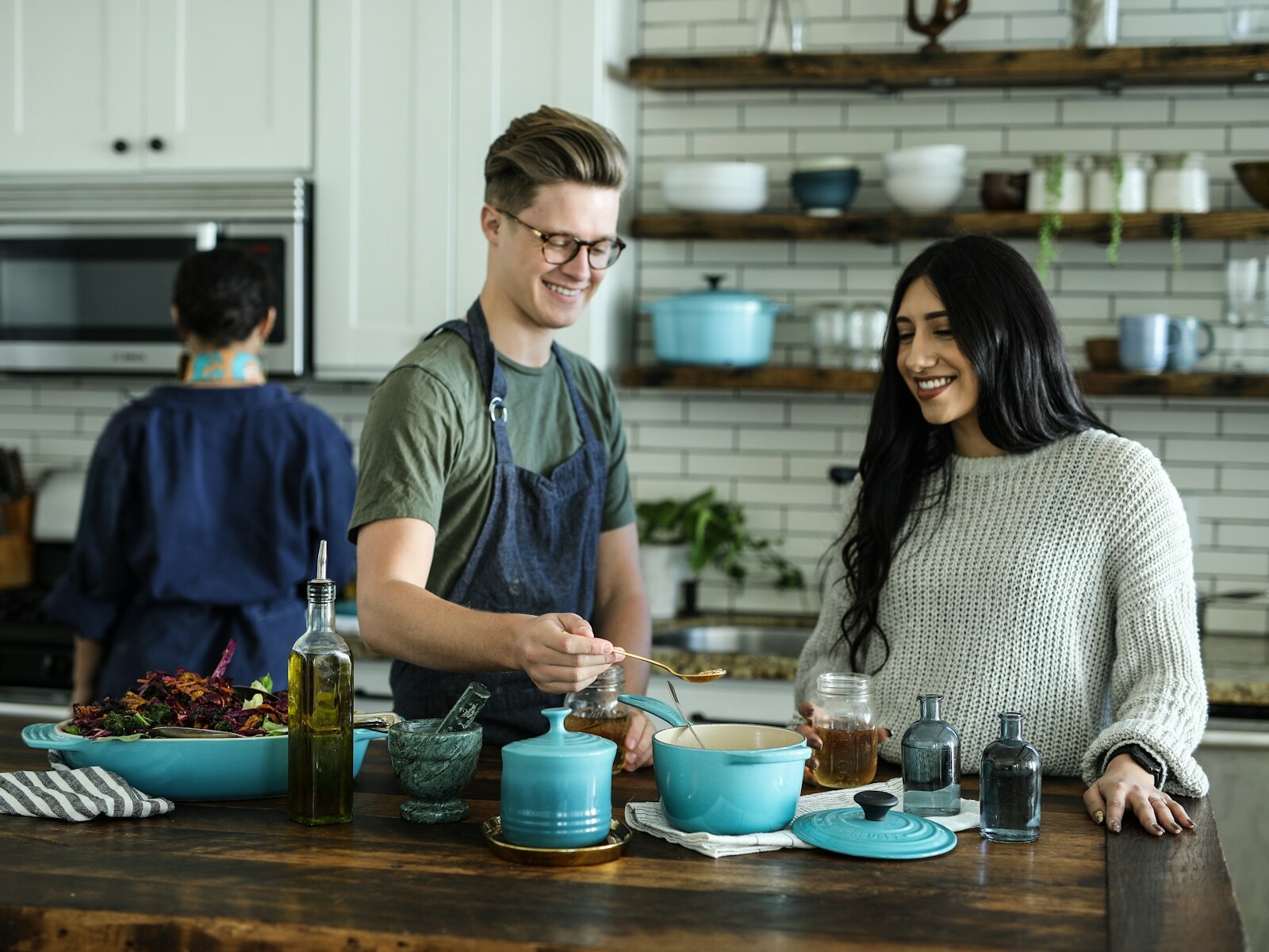 smiling man standing and mixing near woman in kitchen area of the house