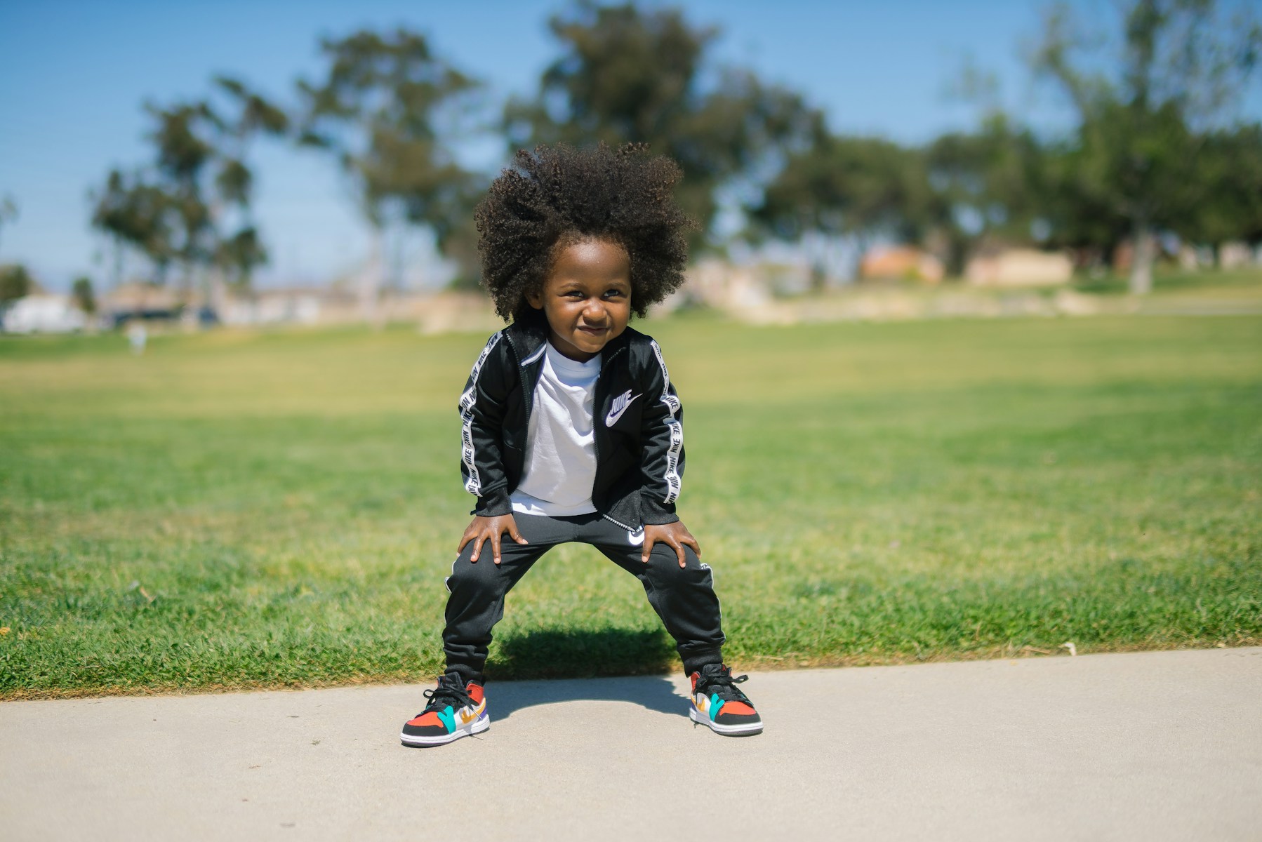 a little girl standing on top of a sidewalk